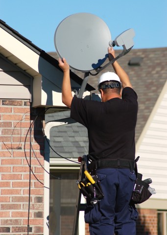 A Man Installing a Satellite Antenna for a Home