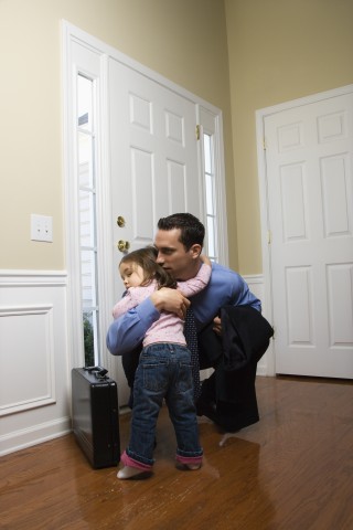 A Father Hugging His Young Daughter before Leaving for Work