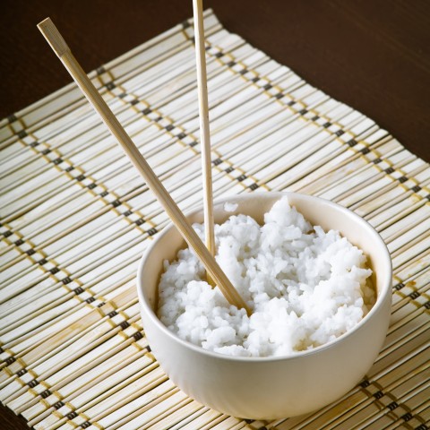 A Bowl of White Rice with Chopsticks In It