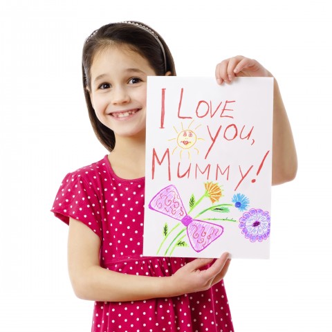 Little Girl Holding a Card that Says “I Love You Mommy”