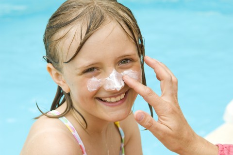 Young Girl Smiling with Sunscreen on Face