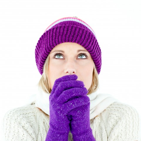 A Woman with a Sweater, Hat, and Gloves Shivering in the Cold