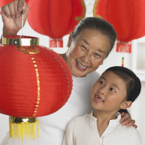 Chinese Man Hanging a Spring Lantern Festival Lantern with Grandson