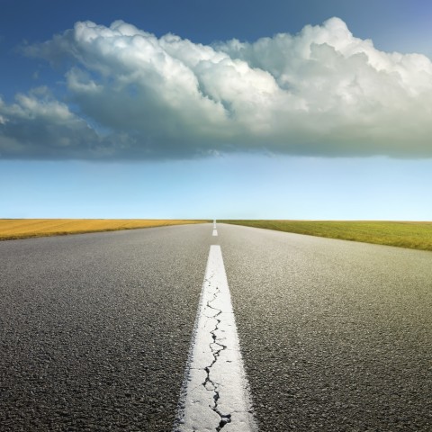 A Straight Road Showing a Path with Some Clouds in the Sky