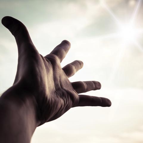 A Hand Raised Toward the Sky in Light of a Revelation