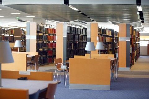 Book Shelves, Desks and Chairs in a Library without People