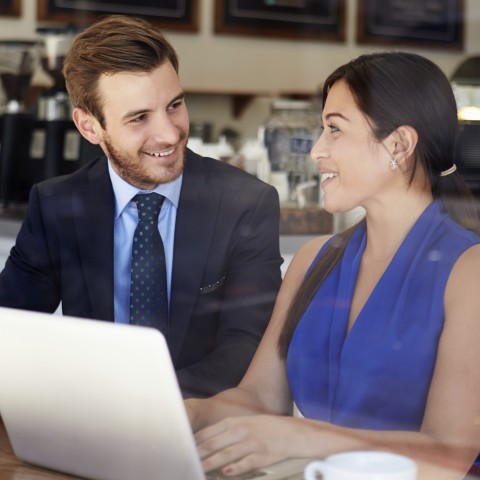 A Man and Woman Flirting while Working on a Laptop