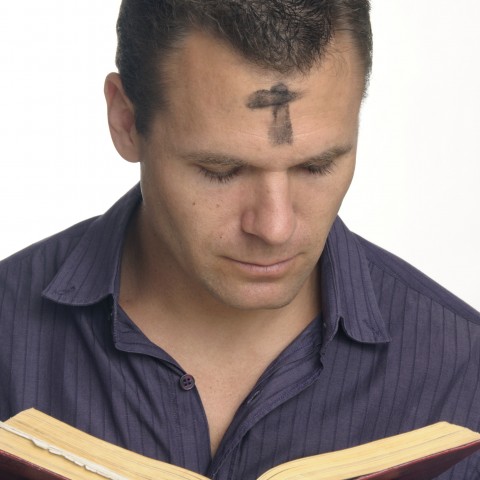 A Man with an Ash Cross on His Forehead Reading the Bible for Ash Wednesday