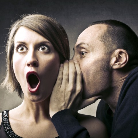 A Man Whispering a Rumor to a Woman