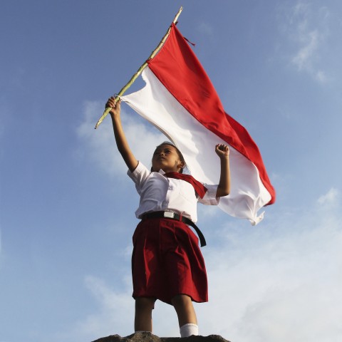 An Indonesian Girl Holding the Indonesian Flag Triumphantly