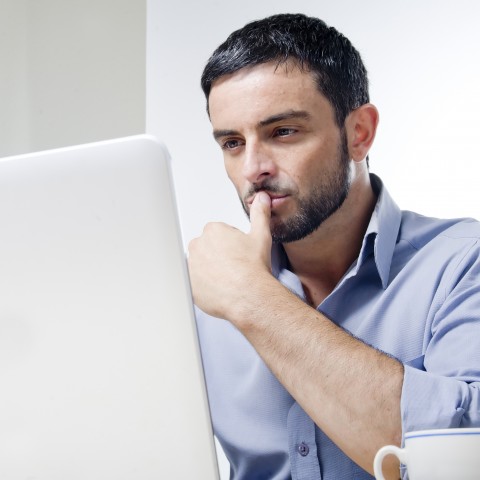 A Man Is Sitting in Front of a Laptop