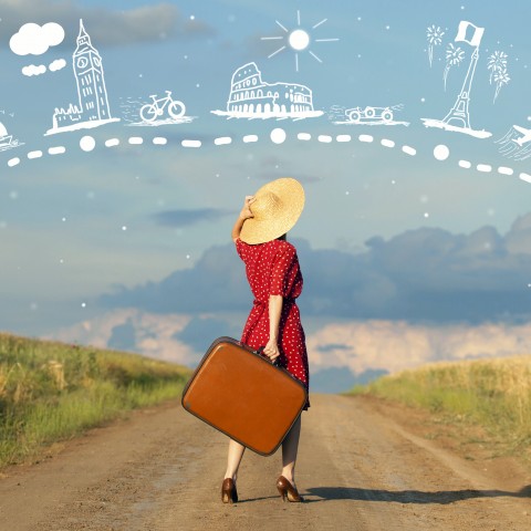 A Woman in a Red Dress and Heels Holding a Suitcase in the Middle of a Dirt Road