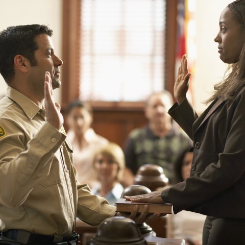 Two People Swearing an Oath on the Bible in Court