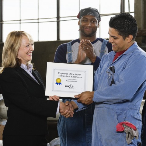 A Pleased-Looking Employee Receiving a Certificate of Excellence