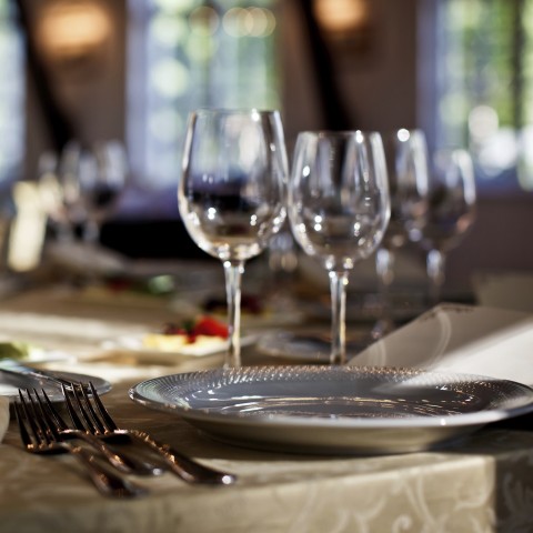 A Table Set with Wine Glasses, Silverware, and Plates