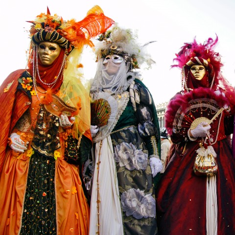 Three People Dressed Up in Carnival Masquerade Attire