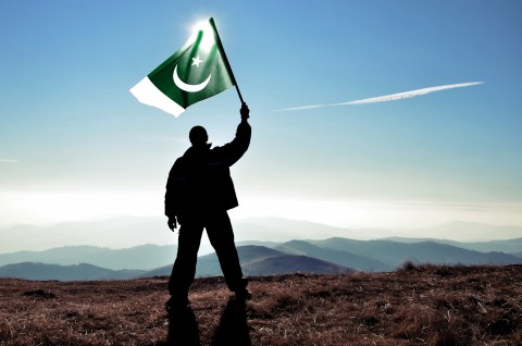 A Man Dressed in Pants and Shirt Waving Pakistani Flag Signifying Cultural Hybridity