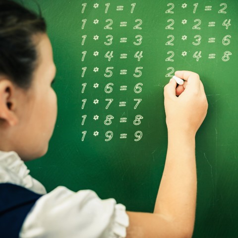 A Student Writing Math Problems on the Board