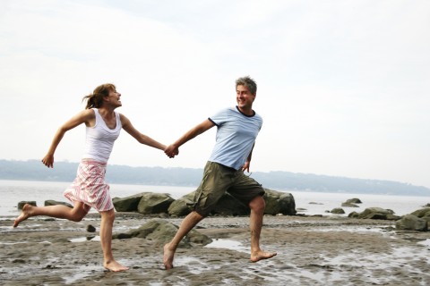 A Couple Running Along a Beach