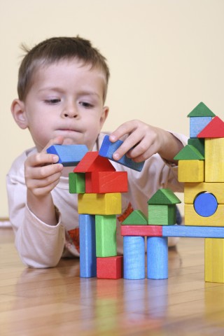 A Child Playing with Colored Wooden Blocks