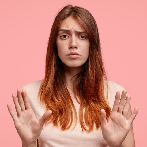 A Woman Holding Her Hands in Front of Her to Say No or Stop