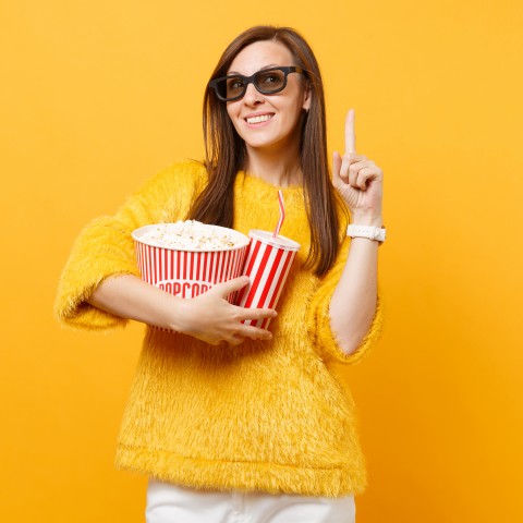 A Woman at the Movies Holding Popcorn and a Drink