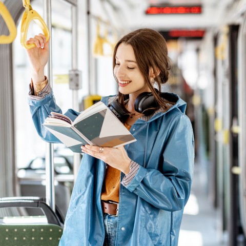 A Woman Reading a Book on a Bus