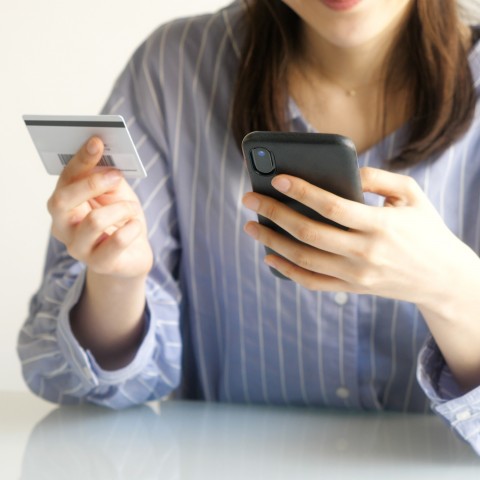 A Woman Inputting Her Credit Card Number into a Cell Phone