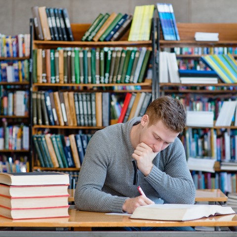 A Man Sitting in a Library and Studying