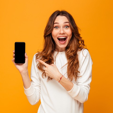 A Happy Woman Pointing to Her Cell Phone