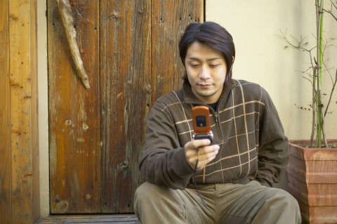 A Man on the Porch Using His Cell Phone