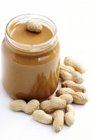 A Jar of Peanut Butter Surrounded by Peanuts