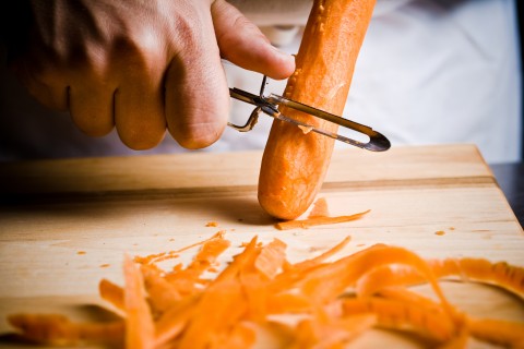 A Hand Peeling Some Carrots