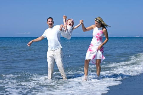 A Couple Playing with Their Child in the Ocean