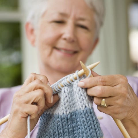 An Older Woman Knitting Something