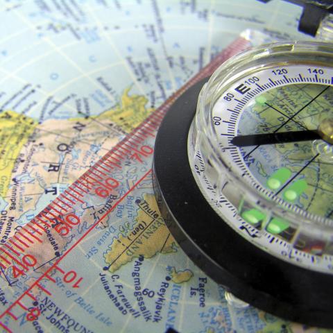 A black compass on a colored map