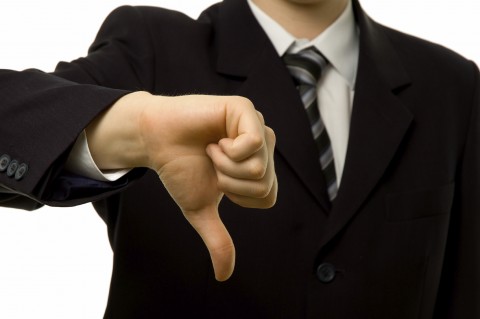 A Man in a Suit Showing Thumbs Down