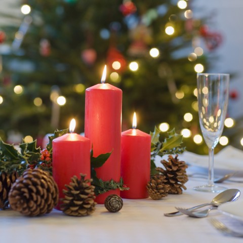 Festive Christmas candles and pinecones on a table