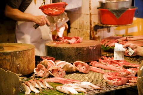 Shopper Handing Out Money at a Meatshop