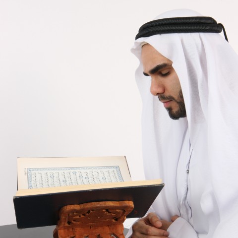 A Muslim Man Reading the Quran and Praying