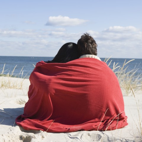 Couple on Beach Wrapped in Blanket