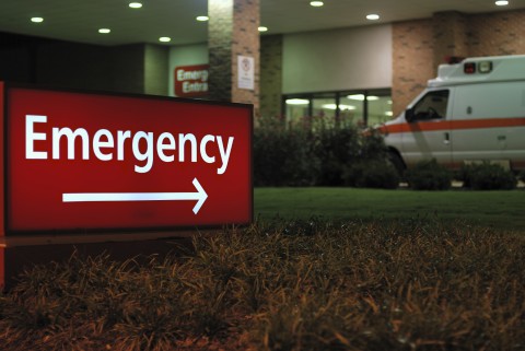 An Emergency Sign with an Ambulance in the Background
