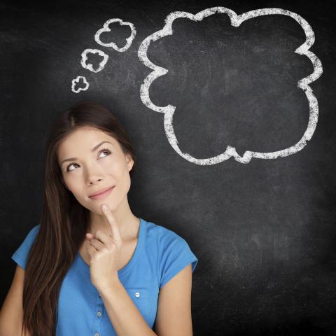 A Woman Deep in Thought in Front of a Blackboard