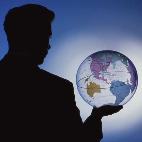 Silhouetted Figure Holding Globe