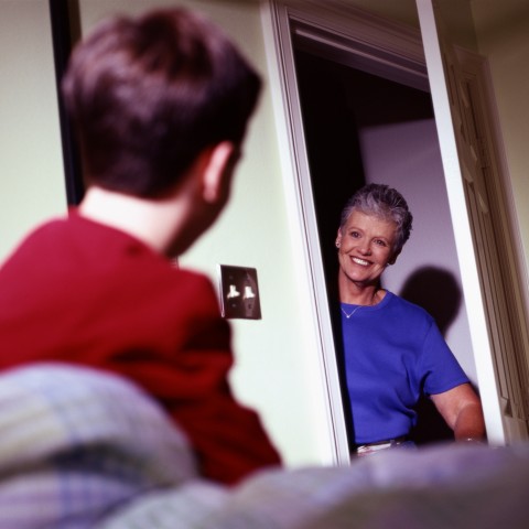 A Smiling Older Woman at a Door.