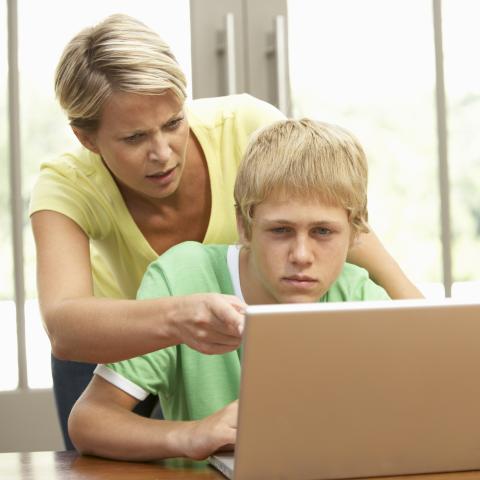 A Mother and Her Son Discussing Something That Is Shown on a Laptop