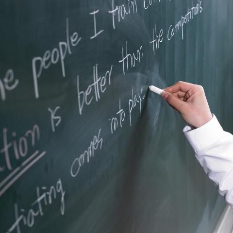 A Person Writing on a Chalkboard