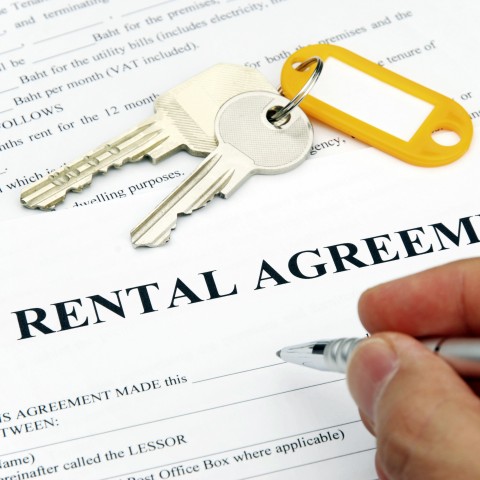 Keys and a rental agreement being signed
