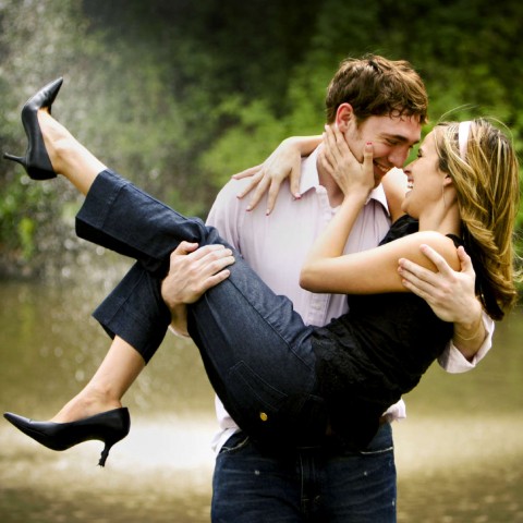 A Man Carrying His Girlfriend Near a Waterfall