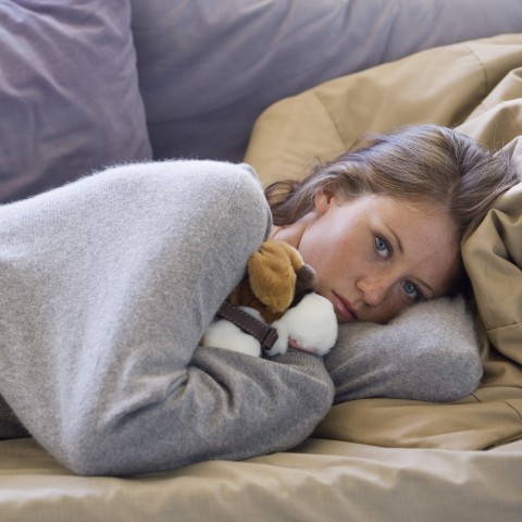 A Girl Lying on the Couch, Holding a Stuffed Animal